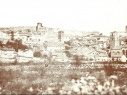 Vista general de Cuéllar a principios del siglo XX. A destaca la torre y la iglesia de Santiago y la desaparecida puerta de San Pedro.